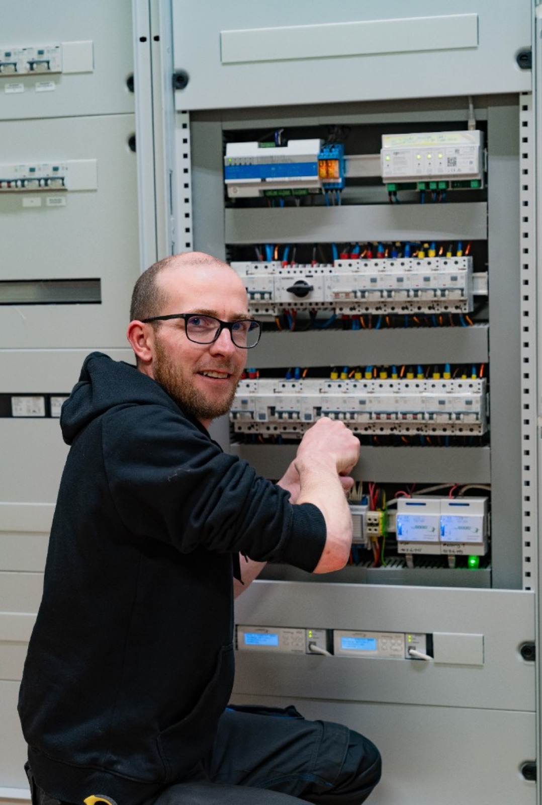 Elektroinstallateur bei der Arbeit am Schaltschrank